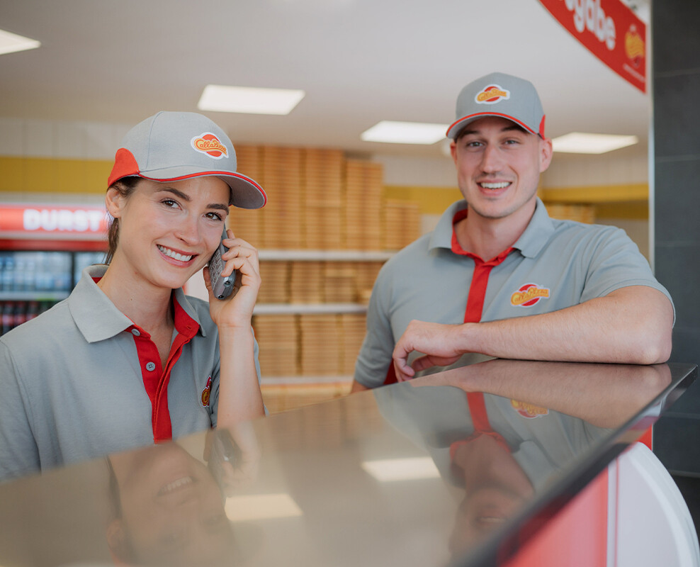 Frau und Mann in Call-A-Pizza Kleidung