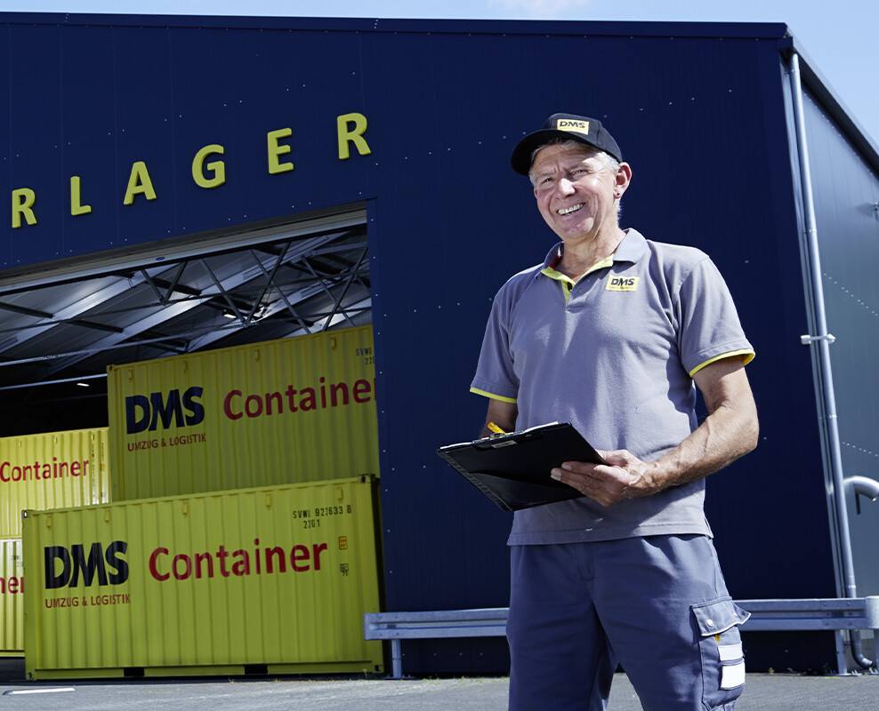 Mann in DMS Workwear vor einem Containerlager