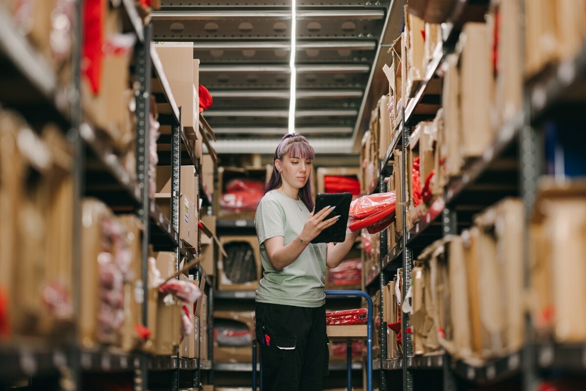 Eine Lageristin hält ein Tablet in der Hand