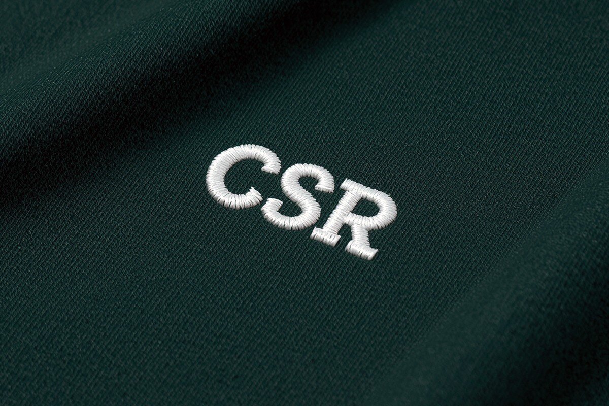 Eine "CSR" Stickerei auf einem grünen Textil